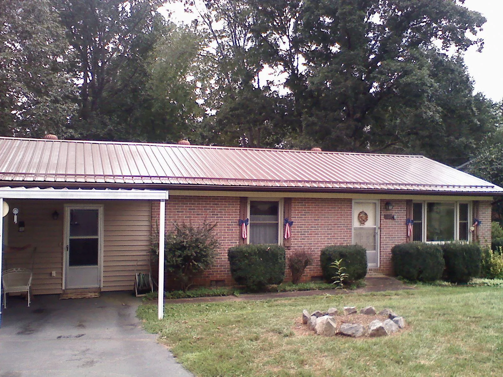 Bronze metal roof and carport on a brick ranch home — Roof Repair work by our crew in Inver Grove Heights